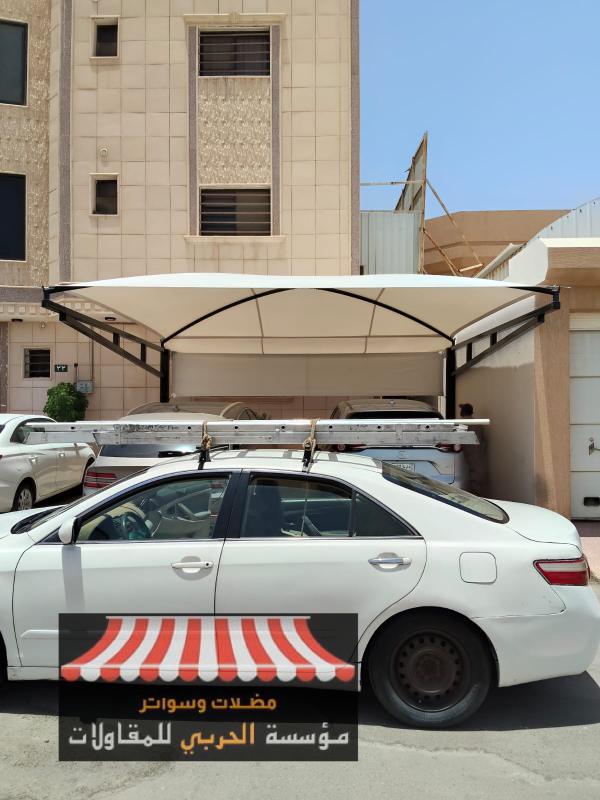 
مظلات مواقف
شركة مظلات وسواتر الحربي تعد من الشركات الرائدة في المملكة العربية السعودية في مجال تصميم وتركيب مظلات مواقف السيارات، حيث تجمع بين الخبرة الهندسية والجودة العالية لتقديم حلول عملية وجمالية تناسب مختلف البيئات والمباني وتدرك الشركة أهمية حماية المركبات من العوامل الجوية القاسية مثل الشمس الحارقة، الأمطار، والرياح، لذا تقدم مظلات مصنوعة من خامات ممتازة مثل الحديد المجلفن، الألمنيوم، وأقمشة PVC وPVDF المقاومة للعوامل المناخية، كما توفر تصاميم متنوعة تشمل المظلات الثابتة، القابلة للسحب، والمظلات ذات الشد الإنشائي، لتلبية احتياجات العملاء من حيث المساحة، الشكل، والوظيفة.ماهي مظلات مواقف
مظلات مواقف هي هياكل هندسية تستخدم لتوفير الحماية للمركبات أثناء توقفها، سواء في الأماكن العامة أو الخاصة وتعد من الحلول العملية والضرورية في البيئات الحضرية الحارة أو الممطرة، حيث تساهم في الحفاظ على السيارة من التلف الناتج عن العوامل الجوية.
مكونات مظلات المواقف
الهيكل الأساسي: غالبًا ما يصنع من الحديد المجلفن أو الألمنيوم المقاوم للصدأ.
غطاء المظلة: يستخدم فيه قماش PVC، بوليستر مشدود، أو ألواح لوكسان الشفافة.
الدعائم والتثبيت: أعمدة أرضية أو تثبيت جداري حسب التصميم والموقع.أهمية مظلات مواقف السيارات في ظروف الرياح القوية
في ظروف الرياح القوية، تصبح مظلات مواقف السيارات عنصر مهم في حماية المركبات والبنية التحتية المحيطة بها وأهم النقاط التي توضح أهميتها في مثل هذه الظروف:
الحماية من التلف الناتج عن الرياح
المظلات المصممة جيدًا تمنع تطاير الأجسام أو سقوط أجزاء من الهيكل على السيارات، مما يقلل من خطر الكسر أو الخدوش أو تلف الزجاج الخارجي.
تعزيز السلامة الإنشائية للموقع
عند استخدام مواد قوية مثل الحديد المجلفن أو الألمنيوم المقوى، تصبح المظلات أكثر قدرة على مقاومة ضغط الرياح دون انهيار أو اهتزاز، مما يحمي الأشخاص والممتلكات المحيطة.
أهمية التثبيت المحكم
التثبيت باستخدام قواعد خرسانية، دعامات إضافية، أو كابلات مشدودة يضمن ثبات المظلة في مواجهة الرياح العاتية، هذا يمنع الانقلاب أو الانزلاق الذي قد يسبب حوادث خطيرة.
الصيانة الدورية والفحص الوقائي
الفحص المنتظم يساعد في اكتشاف أي ضعف أو تلف في الهيكل أو القماش قبل أن يتحول إلى خطر أثناء العواصف، الصيانة السريعة تطيل عمر المظلة وتحافظ على أدائها.
التصميم المقاوم للرياح
بعض الشركات تقدم مظلات بتصاميم هندسية خاصة تقلل من مقاومة الرياح، مثل الأشكال المنحنية أو المائلة التي توجه الرياح بعيدًا عن الهيكل.
أفضل شركة مظلات مواقف
شركة مظلات وسواتر الحربي تعد من أبرز الشركات المتخصصة في تركيب مظلات مواقف السيارات والسواتر في المملكة العربية السعودية، وتتميز بتقديم حلول متكاملة تجمع بين الجودة، التصميم العصري، والأسعار التنافسية وأبرز خدمات الشركة:
تركيب مظلات مواقف سيارات: تشمل مظلات حديد، قماش PVC، مظلات شد إنشائي، ومظلات لكسان، مع ضمان يصل إلى 10 سنوات.
تصاميم حديثة: توفر مظلات قابلة للسحب وثابتة، بأشكال هندسية متنوعة تناسب الفلل، المدارس، والمباني التجارية.
توريد وتركيب سواتر: خشب، حديد، قماش، شينكو، لكسان، وغيرها، مع خيارات متعددة للألوان والتصاميم.
خدمة تركيب الهناجر والمستودعات: باستخدام ألواح ساندوتش بانل لعزل حراري وصوتي عالي الجودة.
جلسات خارجية وبرجولات: تصميم وتنفيذ جلسات حدائق وبرجولات خشبية ومعدنية بأناقة عملية.العوامل التي يجب مراعاتها عند اختيار مظلة مواقف السيارات
اختيار مظلة مناسبة لمواقف السيارات يتطلب مراعاة مجموعة من العوامل لضمان الأداء الجيد، السلامة، والجمالية وأهم النقاط التي ينبغي الانتباه لها:
نوع المواد المستخدمة
يفضل استخدام مواد قوية مثل الحديد المجلفن أو الألمنيوم المقوى لمقاومة الصدأ والرياح.
بالنسبة للغطاء، ينصح بأقمشة PVC أو ألواح لوكسان لمقاومة الأشعة فوق البنفسجية والمطر.
التصميم الهندسي
يجب أن يكون التصميم مقاومًا للرياح، خاصة في المناطق المفتوحة أو ذات الطقس المتقلب.
التصاميم المنحنية أو المائلة تساعد في توجيه الرياح بعيدًا عن الهيكل، مما يقلل من الضغط عليه.
المساحة المتاحة
تحديد أبعاد الموقف بدقة يساعد في اختيار مظلة تغطي السيارة بالكامل دون إعاقة الحركة.
يراعى وجود مساحة كافية للتركيب والتثبيت الآمن.
طريقة التثبيت
يجب أن تكون المظلة مثبتة على قواعد خرسانية أو دعامات قوية لضمان الثبات.
يفضل استخدام أنظمة تثبيت متطورة مثل الكابلات المشدودة أو الدعامات الجانبية.
الميزانية والتكلفة
تختلف الأسعار حسب نوع المواد والتصميم، لذا من المهم موازنة الجودة مع التكلفة.
بعض الشركات تقدم ضمان طويل الأمد، مما يعزز القيمة مقابل المال.
الجمالية والتناسق المعماري
يراعى أن يتناسب شكل المظلة مع تصميم المبنى أو الموقع، سواء كان حديث أو كلاسيكي.
تتوفر خيارات متعددة من الألوان والتشطيبات لإضفاء لمسة جمالية.
سهولة الصيانة
يفضل اختيار مظلات لا تتطلب صيانة متكررة، مع إمكانية تنظيفها بسهولة.
الفحص الدوري يضمن استمرار الأداء الجيد ويمنع التلف المفاجئ.تصميمات مظلات مواقف
مجموعة من تصميمات مظلات مواقف السيارات التي تجمع بين العملية والجمال، وتناسب مختلف البيئات والمشاريع:
مظلات كابولي (Cantilever)
هذا النوع يتميز بتصميمه الذكي الذي لا يحتاج إلى أعمدة أمامية، مما يتيح دخول وخروج سلس وسريع للمركبات دون عوائق، يثبت هيكل المظلة من جهة واحدة فقط، وغالبًا على الجدار الخلفي أو الجانبي، مما يجعله مثالي لمداخل الفلل، ساحات المدارس، أو مواقف الشركات كما يمنح المظهر الخارجي انسيابية وأناقة، خاصة عند استخدام الهياكل المعدنية مع أقمشة مقاومة للحرارة والمطر.مظلات هرمية
تأتي بشكل هرمي مائل يشبه الخيام، وتصنع عادةً من أقمشة PVC أو بوليستر ذات مقاومة عالية للعوامل الجوية ويتناسب هذا النوع مع الأماكن المفتوحة التي تحتاج إلى تغطية واسعة بتصميم جذاب، مثل مواقف المجمعات التجارية، الحدائق، أو المدارس وتضيف هذه المظلات لمسة جمالية وتحسن من بيئة الوقوف من حيث الحماية والتهوية.مظلات شد إنشائي (Tensile Structures):
هي مظلات حديثة التصميم، تعتمد على مبدأ التوتر الإنشائي باستخدام قماش مشدود على قواعد معدنية بتوزيع مدروس للقوى لتمنح مرونة كبيرة في الشكل، وتُستخدم في المشاريع الكبرى كالمطارات، المستشفيات، والمراكز الرياضية، جمالها يكمن في إمكانية تشكيلها هندسي بطريقة انسيابية ومعاصرة، مع عمر افتراضي طويل ومقاومة للرياح القوية والأشعة فوق البنفسجية.مظلات معلقة
تثبت على الجدران أو الهياكل الرأسية دون الحاجة إلى أعمدة أرضية، مما يوفر مساحة أرضية أكبر ويُضفي شعورًا بالانفتاح ويفضل هذا النوع في الأماكن ذات المساحة المحدودة، مثل المباني متعددة الطوابق، الفلل ذات المداخل الضيقة، أو المواقف بجانب الجدران، ليمكن تصميمها بمرونة لتناسب الشكل المعماري للموقع دون التأثير على الحركة أو المنظر العام.مظلات لكسان (Lexan)
تعتمد على ألواح شفافة أو نصف شفافة مصنوعة من مادة لوكسان، وهي مادة مقاومة للخدوش والأشعة فوق البنفسجية، لتمنح هذه المظلات إنارة طبيعية للمواقف، خاصة في الأماكن المغلقة أو التي تتطلب رؤية واضحة، مثل مواقف المدارس أو الشركات وتصميمها العصري يتكامل مع الواجهات الزجاجية أو الحديدية، وهي مثالية لمن يبحث عن حماية دون عزل الضوء.
كيفية تثبيت مظلات متينة لمواقف السيارات
تثبيت مظلات متينة لمواقف السيارات في ظروف الرياح العاتية يتطلب تنفيذ هندسي دقيق واختيار مدروس للمواد والتصميم، واهم الخطوات الأساسية لضمان الثبات والمتانة ما يلي:تأسيس قواعد خرسانية قوية
لبناء مظلة متينة، يجب البدء بقواعد خرسانية ذات عمق يتراوح بين 60 إلى 100 سم حسب نوع الأرض، يفضل استخدام الخرسانة المسلحة المدعمة بقضبان تسليح لضمان تحمل الاهتزازات والضغوط الناتجة عن الرياح القوية، مما يوفر استقرار طويل الأمد للهيكل.
استخدام هيكل معدني مقاوم للرياح
لا بد من اختيار هيكل مصنوع من حديد مجلفن بسماكة مناسبة (لا تقل عن 2 ملم) أو من ألمنيوم مقوى، فهذه المواد توفر متانة عالية ومقاومة للصدأ والعوامل الجوية وينبغي أن تكون الوصلات بين القطع ملحومة بطريقة كهربائية وليس بالربط التقليدي لضمان تحمل أقصى درجات التوتر.
دعم إضافي باستخدام شدادات وكابلات
في المناطق المعرضة للرياح العاتية، يُوصى بتركيب كابلات مشدودة تربط أعلى المظلة بالقواعد الأرضية، كما يمكن إضافة دعامات جانبية أو متقاطعة بين الأعمدة لتوزيع الضغط بشكل متوازن وتقليل حركة الهيكل عند هبوب الرياح.اختيار تصميم مقاوم للرياح
التصاميم المنحنية أو المائلة لها ميزة هندسية في توجيه الرياح بعيدًا عن الهيكل ويفضل تجنب الأسطح المسطحة لأنها تحدث مقاومة عالية للرياح، مما قد يؤدي إلى انقلابات أو اهتزازات ضارة.
الفحص والصيانة الدورية
المتابعة المستمرة لصحة الهيكل، نقاط التثبيت، والقماش أو ألواح التغطية تساهم في الحفاظ على المظلة في أفضل حالاتها، لينصح بإجراء الفحص كل 3 إلى 6 أشهر وإصلاح أي خلل فورًا، كتمزق القماش أو تأكسد المعدن.الالتزام بإرشادات الشركة المصنعة
اتباع تعليمات التركيب الواردة من الشركة المصنعة يضمن أداء مثالي ويطيل عمر المظلة ومن الأفضل أيضًا التعاقد مع شركات متخصصة تقدم ضمان على التركيب لضمان الجودة والسلامة.
نصائح لتثبيت المظلة بشكل صحيح وتعزيز استقرارها في حالة الرياح القوية
تثبيت مظلات مواقف السيارات بشكل صحيح في مناطق تتعرض للرياح القوية يتطلب دقة في التصميم والتنفيذ وأهم النصائح العملية لضمان الثبات والسلامة ما يلي:استخدم حديد مجلفن أو ألمنيوم مقوى للهياكل، فهي تتحمل الضغط العالي دون تشوه.
اختر أقمشة مظلات مثل PVC أو PVDF المقاومة للتمزق والتآكل بفعل الرياح.
يجب أن تُثبت الأعمدة على قواعد خرسانية بعمق مناسب (عادة 60–100 سم حسب نوع الأرض).
يفضل استخدام براغي تثبيت صناعية ومادة لاصقة مقاومة للاهتزازات.
أضف كابلات مشدودة أو دعامات جانبية لتوزيع الضغط وتقليل حركة الهيكل أثناء العواصف.
في المظلات الكبيرة، ينصح باستخدام دعامات متقاطعة بين الأعمدة لزيادة التماسك.
افحص نقاط التثبيت، حالة القماش، والهيكل المعدني كل 3–6 أشهر.
أي تمزق أو صدأ يجب إصلاحه فورًا لتجنب تفاقم المشكلة.
اختر تصاميم منحنية أو مائلة لتقليل مقاومة الرياح وتوجيهها بعيدًا عن الهيكل.
تجنب الأسطح المسطحة تمامًا في المناطق المفتوحة، لأنها تزيد من خطر الانقلاب.في ختام الحديث عن مظلات المواقف، يمكن القول إنها لم تعد مجرد وسيلة لحماية المركبات من أشعة الشمس أو الأمطار، بل أصبحت عنصر متكامل في تخطيط المساحات الحضرية والبيئية للمرافق العامة والخاصة إذ تسهم في تحسين جودة الحياة، وتعكس اهتمامًا بتوفير حلول عملية وآمنة، كما أن الخيارات المتنوعة في التصميم والمواد تتيح مواءمتها مع مختلف الأنماط المعمارية، لتضفي طابع جمالي بجانب وظيفتها الأساسية.مظلات مواقف
